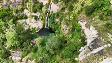 Bir şelale kayalık bir uçurumdan aşağı akıyor.