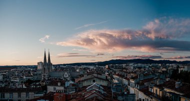 Marsilya üzerinde katedral kuleleriyle dramatik günbatımı