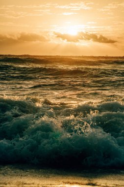 Dalgalı okyanus dalgaları üzerinde altın gün doğumu, Playa Del Carmen