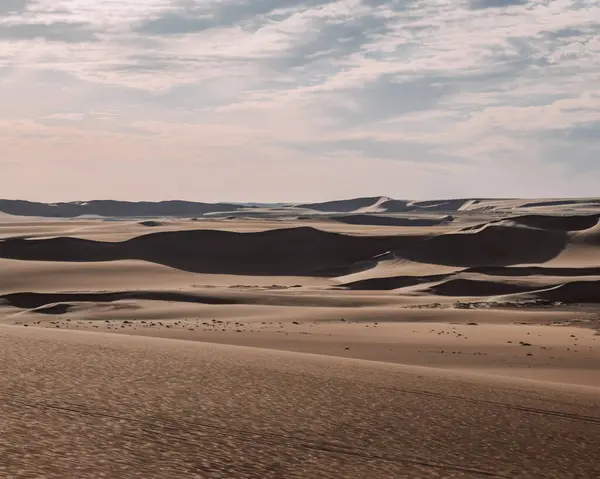 stock image Expansive sandy dunes under a partially cloudy sky, Sahara near Siwa Oasis, Egypt.