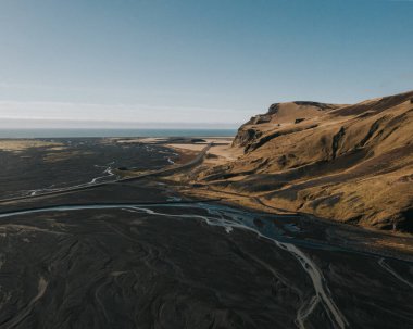 Güney İzlanda 'daki engebeli arazi ve nehrin temiz bir gökyüzü altında havadan görünüşü