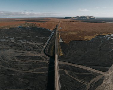 Güney İzlanda 'daki Hjorleifshofdi dağıyla nehir deltası üzerindeki bir köprünün hava görüntüsü.