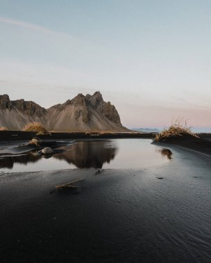 Güneydoğu İzlanda 'daki Stoksnes sahilindeki bir su havuzundaki Vestrahorn dağının yansıması.