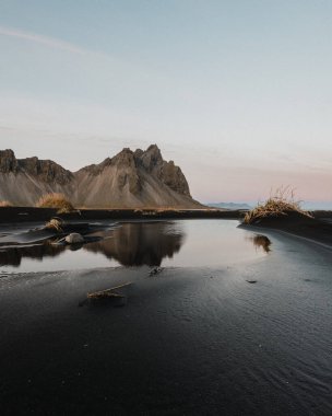 Reflection of Vestrahorn mountain in a water pool on Stokksnes beach, South East Iceland clipart