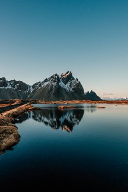 Güneydoğu İzlanda 'daki Stoksnes sahilindeki bir su havuzundaki Vestrahorn dağının yansıması.