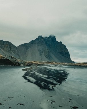 Güneydoğu İzlanda 'daki Stoksnes sahilindeki bir su havuzundaki Vestrahorn dağının yansıması.