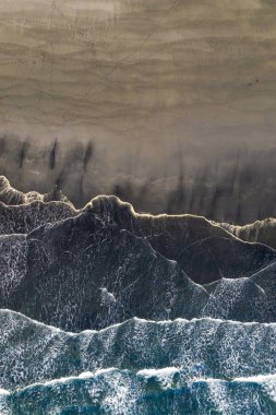 Stoksnes, Güneydoğu İzlanda 'daki kara kum plajındaki dalgaların ve desenlerin hava görüntüsü