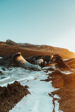 İzlanda 'daki Svinafelljokull buzulu üzerinde sersemletici bir gün doğumu dramatik buzlu manzarayı ve engebeli dağları vurguluyor.