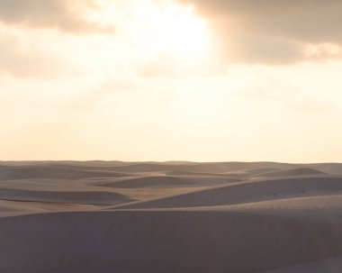 Socotra, Yemen 'deki huzur dolu Zahek Kumulları' nın üzerinde gün doğarken, yumuşak bir ışık kumu aydınlatıyor..