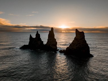 Reynisdrangar deniz yığınları gün batımında İzlanda 'nın güney kıyısında..