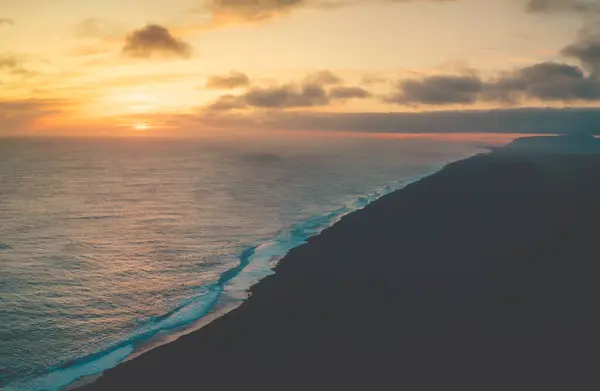 Dyrholaey, İzlanda 'daki siyah kumlu plajda nefes kesici bir gün batımı.