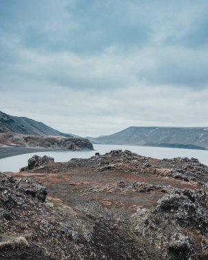 İzlanda 'nın Reykjanes Yarımadası' nın dramatik volkanik manzarasında, siyah kumlu kıyıları ve engebeli uçurumları olan Kleifarvatn Gölü 'nün huzurlu manzarası.