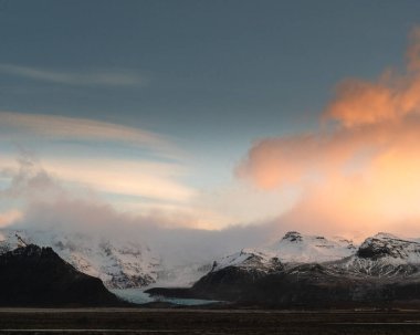 Oraefi, Güney İzlanda 'da karla kaplı dağların üzerinde canlı bir gün doğumu..
