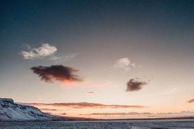 Oraefi, Güney İzlanda 'da karla kaplı dağların üzerinde canlı bir gün doğumu..