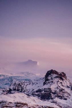 Hvannadalshnukur zirvesi Güney İzlanda 'nın kışında gün batımında bulutlarla örtülüydü..