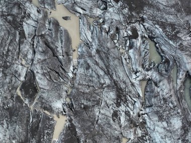 Güney İzlanda 'daki Svnafellsjokull' da buzul dokusu ve erimiş suyun havadan yakın çekimi.
