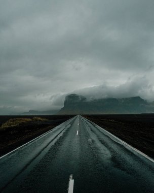 Lomagnupur ve Islak Yol 1 'in kasvetli manzarası Güney İzlanda' nın geniş ovalarını kesiyor..