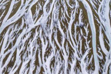 Güney İzlanda 'da kış boyunca karmaşık donmuş nehir şekillerinin havadan görünüşü.