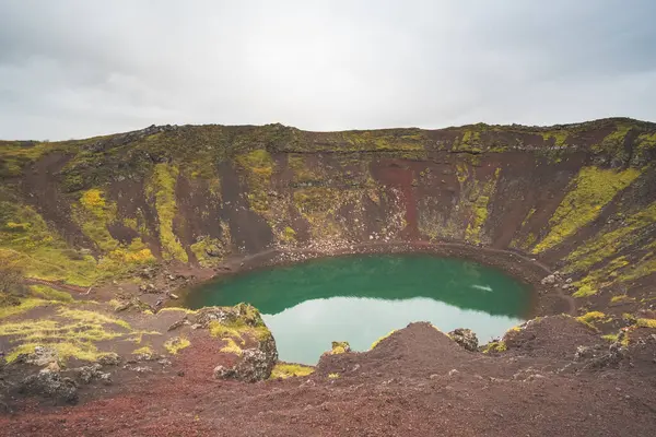 Güney İzlanda 'daki Kerid Krateri' nde canlı kırmızı yamaçlar ve turkuaz su bulunuyor.