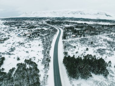 Güney İzlanda 'da kışı geçiren karla kaplı bir yolun hava manzarası.