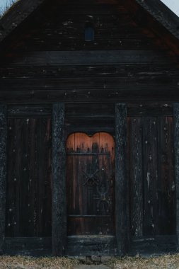 Close-up of a carved wooden door on a traditional turf house in Thorlaksbud, south Iceland clipart