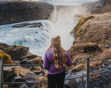 Güney İzlanda 'nın Altın Çemberi' ndeki güçlü Gulfoss şelalesine hayran bir gezgin.