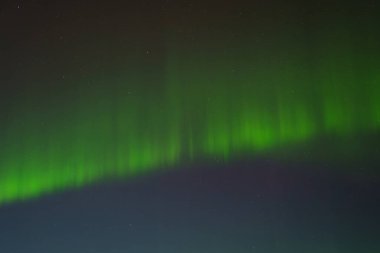 Vivid green aurora borealis lighting up the night sky in Hveragerdi, South Iceland clipart