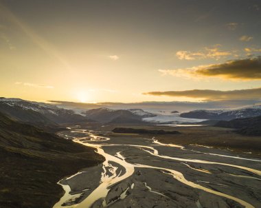 Güney İzlanda 'da gün batımında Hoffellsjokull buzulundan akan örülmüş nehirlerin hava manzarası