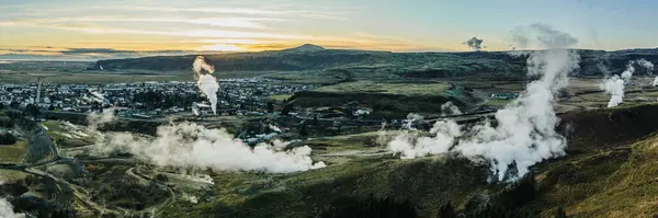 Güney İzlanda, Hveragerdi 'nin hava manzarası, şafak vakti jeotermal buhar delikleri ve engebeli manzaralar sergiliyor..