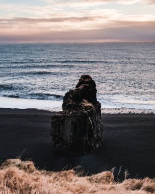 Reynisfjara 'daki Arnardrangur deniz yığını. Güney İzlanda' daki kara kum plajı..