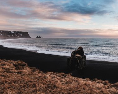 Arnardrangur deniz yığını ve Reynisdrangar bazalt sütunları Güney İzlanda 'da, siyah kumsalda..