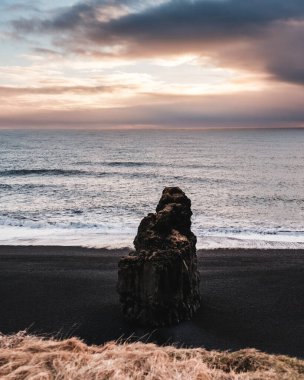 Reynisfjara 'daki Arnardrangur deniz yığını. Güney İzlanda' daki kara kum plajı..