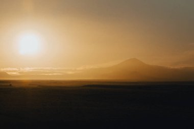 Güney İzlanda 'daki Hekla volkanı üzerinde altın gün doğumu sakin bir manzara yaratıyor..