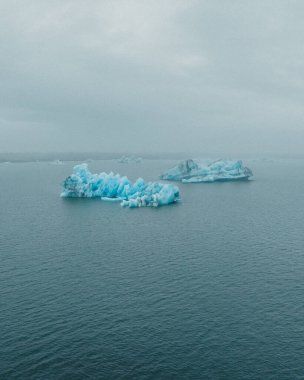 Jokulsarlon Buzul Gölü, İzlanda 'nın sakin sularında yüzen mavi buzdağları.