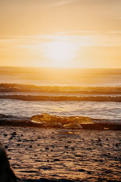 Elmas Sahili 'ndeki buzul buzunu aydınlatan altın gün batımı (Breidamerursandur), Güney İzlanda