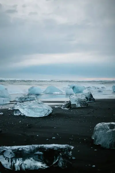 Güney İzlanda 'da, karamsar bir gökyüzünün altında Diamond Sahili' ne dağılmış buzul.