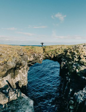 Arnarstapi, Snaefellsnes Yarımadası, Batı İzlanda 'da okyanusun üzerinde duran doğal bir kaya kemeri üzerinde duran maceraperest..