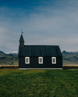Budirkirja 'nın yan manzarası, Budir, Snaefellsnes Peninsula, Batı İzlanda' daki tarihi siyah ahşap kilise, engebeli manzaralarla çevrili..