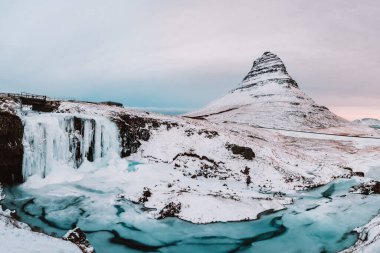 Donmuş Kirkjulsfoss şelalesi ve karla kaplı Kirkjufell dağı, Snaefellsnes Yarımadası, Batı İzlanda