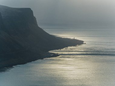 Patreksfjordur, İzlanda 'da gün batımında dramatik kıyı şeridi ve sakin deniz manzarası