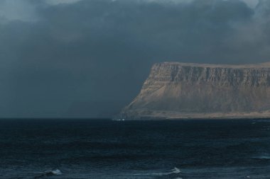 Patreksfjordur, Westfjords, İzlanda 'da denizden karamsar kıyı kayalıkları yükseliyor.