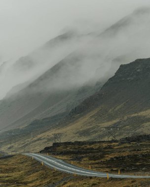 Karamsar bir numaralı yol manzarası sisli Doğu İzlanda tepelerinde dönüyor.