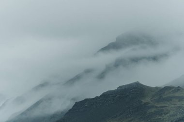 Doğu İzlanda 'da, Cupivogur yakınlarında sisle kaplanmış karamsar dağ sırtları.