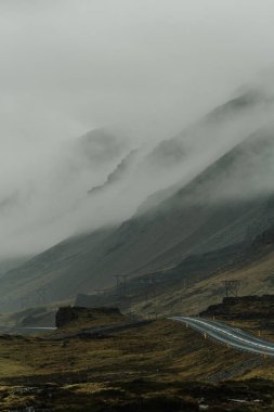 Karamsar bir numaralı yol manzarası sisli Doğu İzlanda tepelerinde dönüyor.