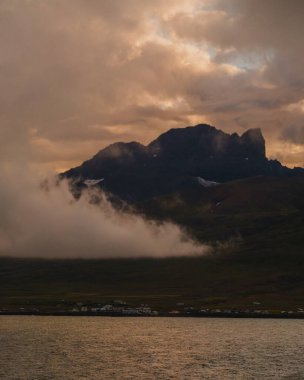 Güneş batarken Borgafjordur Eystri köyünde dramatik bulutlar, Doğu İzlanda