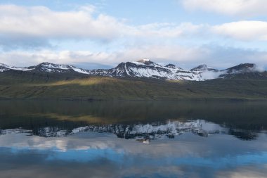 Faşkrudsfjordur, İzlanda 'da sakin fiyortlara yansıyan karla kaplı dağlar