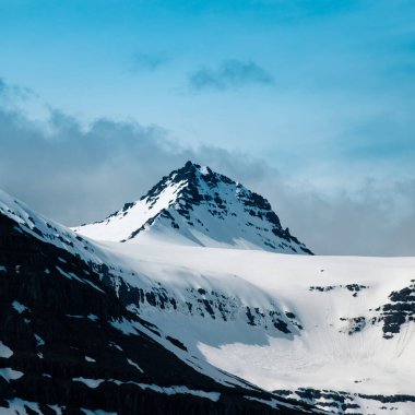 Faşkrudsfjordur, Doğu İzlanda 'da karla kaplı tepeler ve sürüklenen bulutlar
