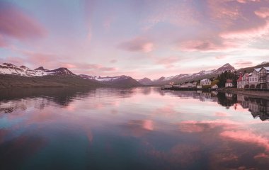 Faşkrudsfjordur kasabası ve İzlanda 'nın karlı dağları üzerinde canlı gün batımı