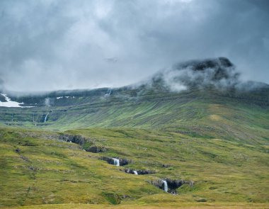Faşkrudsfjordur, Doğu İzlanda 'da şelaleli puslu yeşil dağ yamaçları