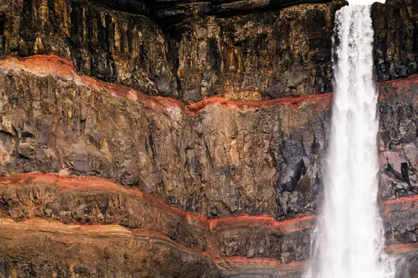 Hengifoss şelalesinin yakın çekimi kırmızı çizgili uçurumları aşıyor.